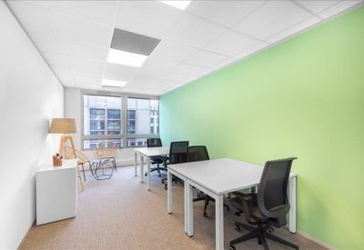 Private four-person office suite with a bright lime green accent wall and large window.
