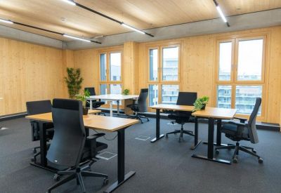 Spacious open-plan workspace with multiple desks and warm timber interiors.