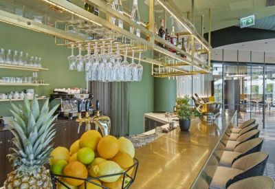 Cafe area with a gold-toned bar counter, hanging glassware, and fresh citrus fruit in the foreground.