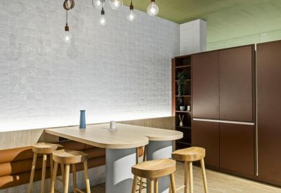 Breakout space featuring a light wood breakfast bar with stools and dark brown storage cabinetry.