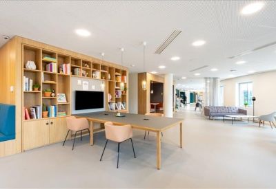 Functional workspace featuring a large desk and a wooden shelving unit filled with books and a TV.
