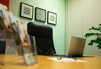 Private office space featuring framed wall art and a lush green plant on the desk.
