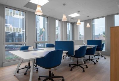 Spacious coworking area with blue chairs and modern hanging lights.