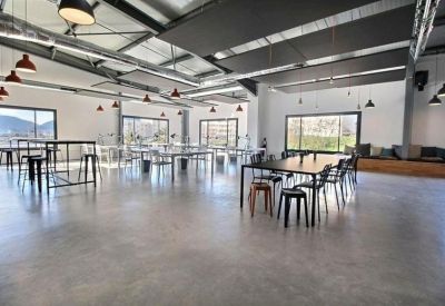 Bright open-plan coworking area with various workstations and modern lighting.
