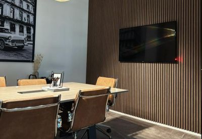 Modern meeting room with wood-slat feature wall and tan leather chairs.