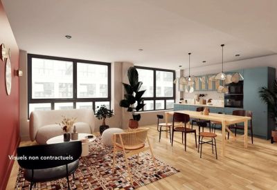 Spacious communal lounge with a white sofa, colorful rug, and large windows.