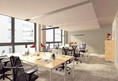 Modern open-plan office with light wood desks and ergonomic mesh chairs.