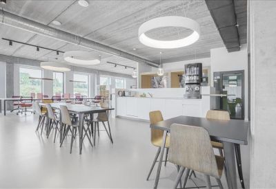 Communal break area and cafe featuring circular pendant lights, dining tables, and a coffee station.