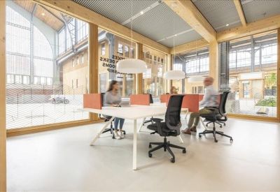 Bright coworking space with timber framing and white desks.