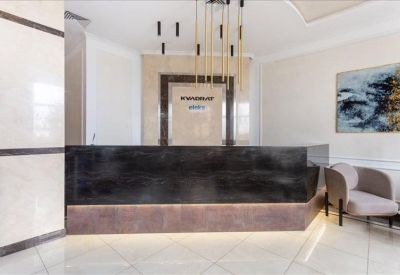 Sleek modern reception desk with warm wood accents and a statement light fixture.