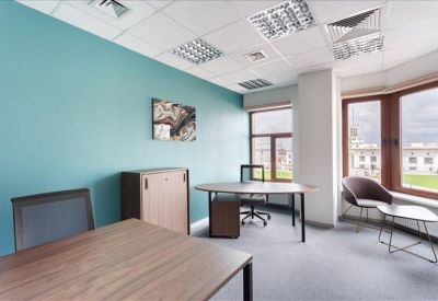 Private office featuring a teal accent wall and large windows overlooking the city.