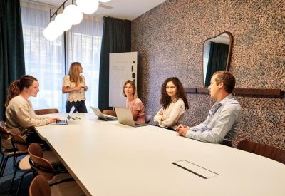 Contemporary meeting room featuring a cork-textured accent wall and large white table.