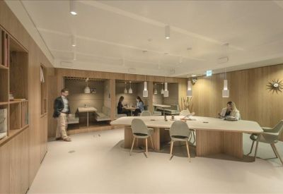 Bright reception area with a white desk, large windows, and a long orange runner rug.