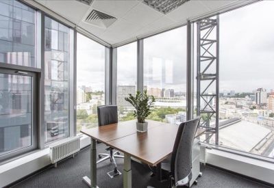Corner office suite with floor-to-ceiling windows and city views.