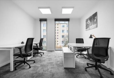 Private office suite with white desks, ergonomic black chairs, and natural light.