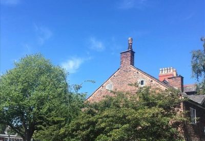 Side view of a historic brick building under a clear blue sky.
