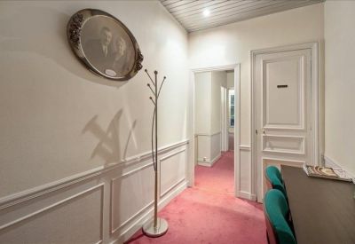 Bright hallway featuring white wall molding, pink carpeting, and a workspace nook.