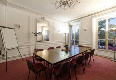 Elegant meeting room with a large table, crystal chandelier, and large windows.