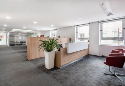 Bright reception area featuring a wooden front desk and indoor plant.
