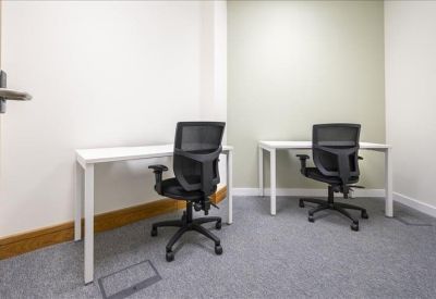 Private two-person office suite with white desks and ergonomic mesh chairs.