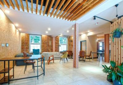 Spacious breakout area with wooden slat ceilings and a mix of colorful armchairs.