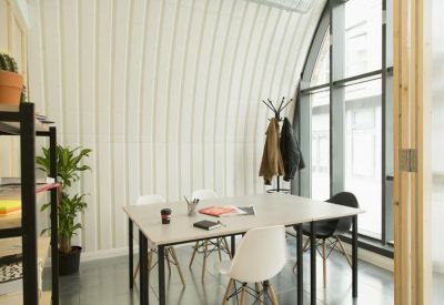 Bright meeting room with a large table, white chairs, and an arched window.