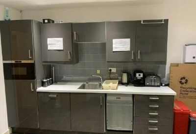 Communal kitchen area with dark grey cabinetry and integrated appliances.