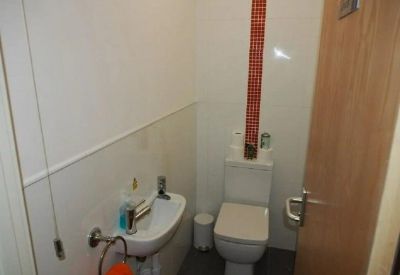 Small ensuite bathroom with a toilet and compact corner sink.