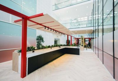 Sleek kitchen breakout area with black cabinetry and red architectural framing.