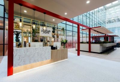 Reception desk featuring marble textures, red structural accents, and hanging bulb lights.