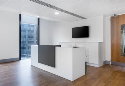 Minimalist reception area with a white and grey desk and warm wood floors.