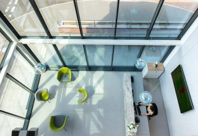 High-angle view of a modern reception area with lime green chairs and a marble desk.