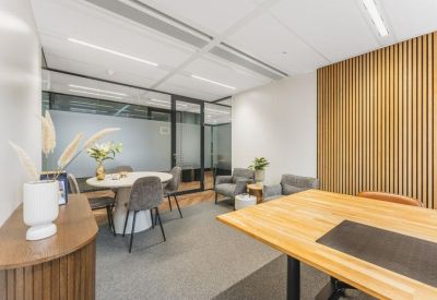 Modern private office suite with a wooden desk, round meeting table, and wood-slat feature wall.