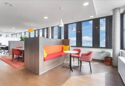 Breakout area featuring a wood-paneled booth with orange and yellow cushions.