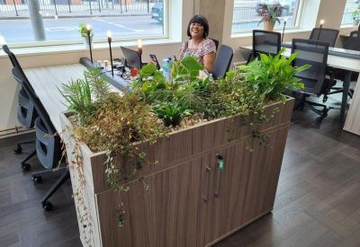 Vast office floor with long desks and large windows showing urban views.