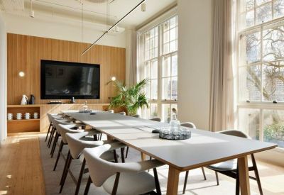 A light-filled meeting room at 1 Temple Avenue featuring a long table and wooden wall paneling.