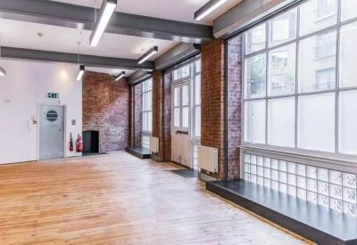 Bright workspace with light wood floors and industrial ceiling beams.