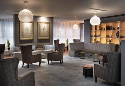 Modern reception desk with a backlit panel and a large geometric shelving unit.