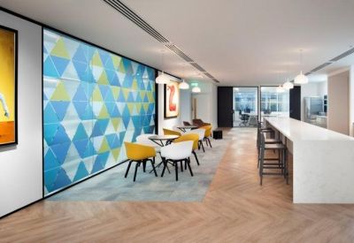 Conference room with two white tables, mesh chairs, and framed artwork on the walls.