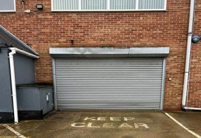 External metal roller shutter door with Keep Clear floor marking.