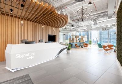 Bright reception area featuring an angular white front desk and decorative wood-slat ceiling feature.