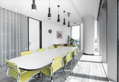 Sleek conference room featuring a long white table, yellow chairs, and modern pendant lighting.