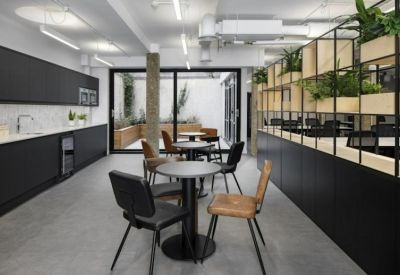 Kitchen and dining area featuring sleek black cabinetry and a wood-slatted room divider with plants.