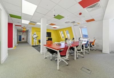 Spacious open-plan office featuring a Star Wars stormtrooper statue and colourful ceiling panels.
