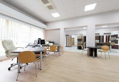 Bright furniture showroom or reception space with light wood flooring and modern seating.