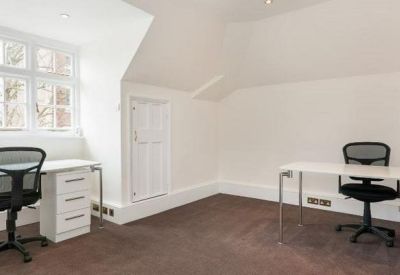 Bright workspace featuring two white desks and ergonomic mesh chairs.