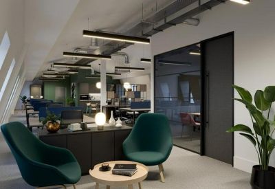 Lounge area with teal velvet armchairs and a view into a glass-walled meeting room.