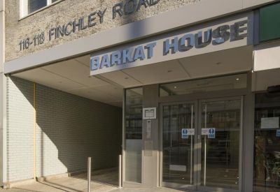 Modern glass-fronted entrance to Barkat House with polished stone walkway.