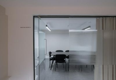 Private meeting room viewed through a glass partition with a frosted band.