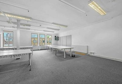 Large open workspace area with neat rows of desks and large windows overlooking the street.